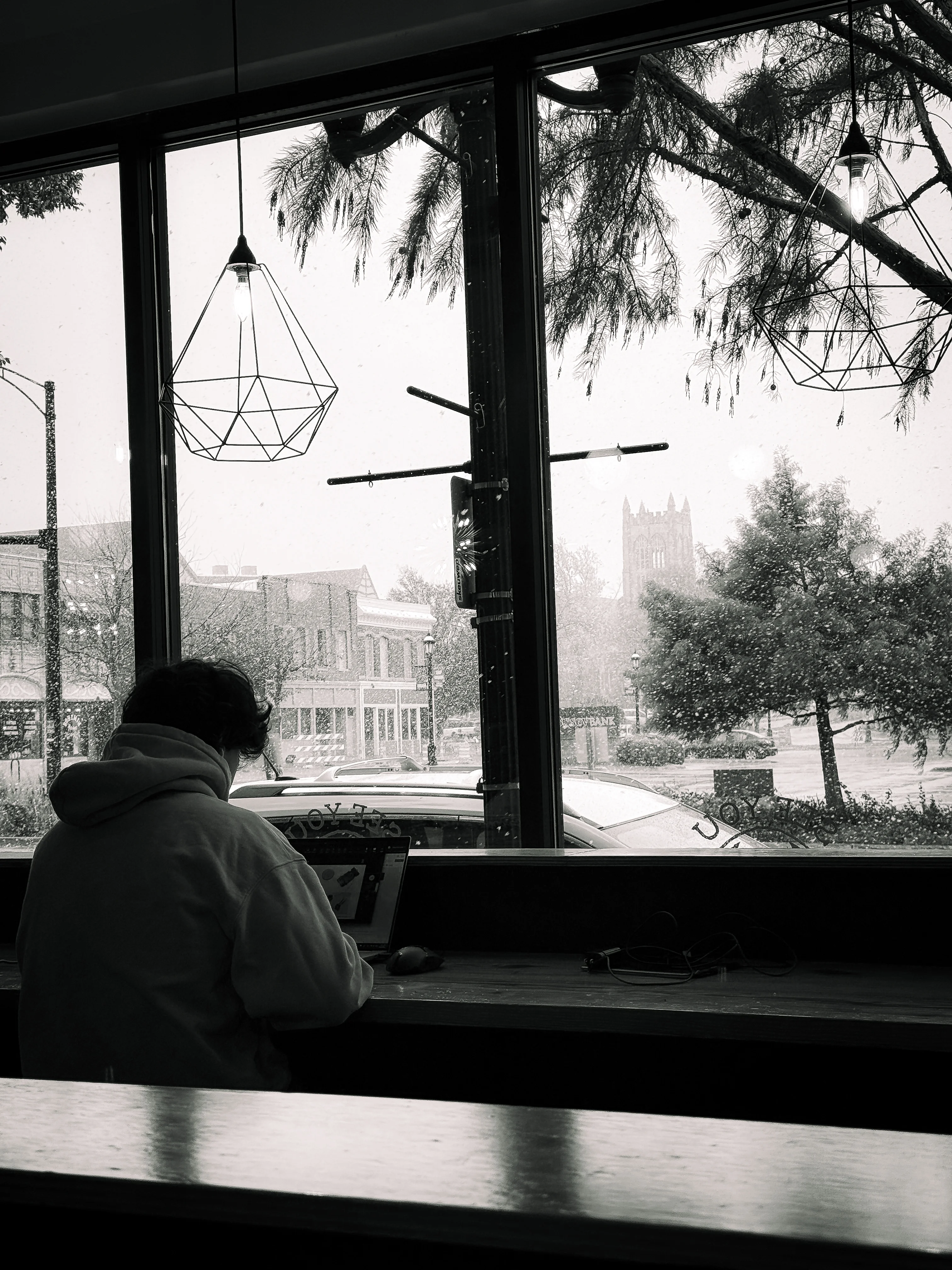 Brand & location — café interior, figure silhouetted at window in snowfall