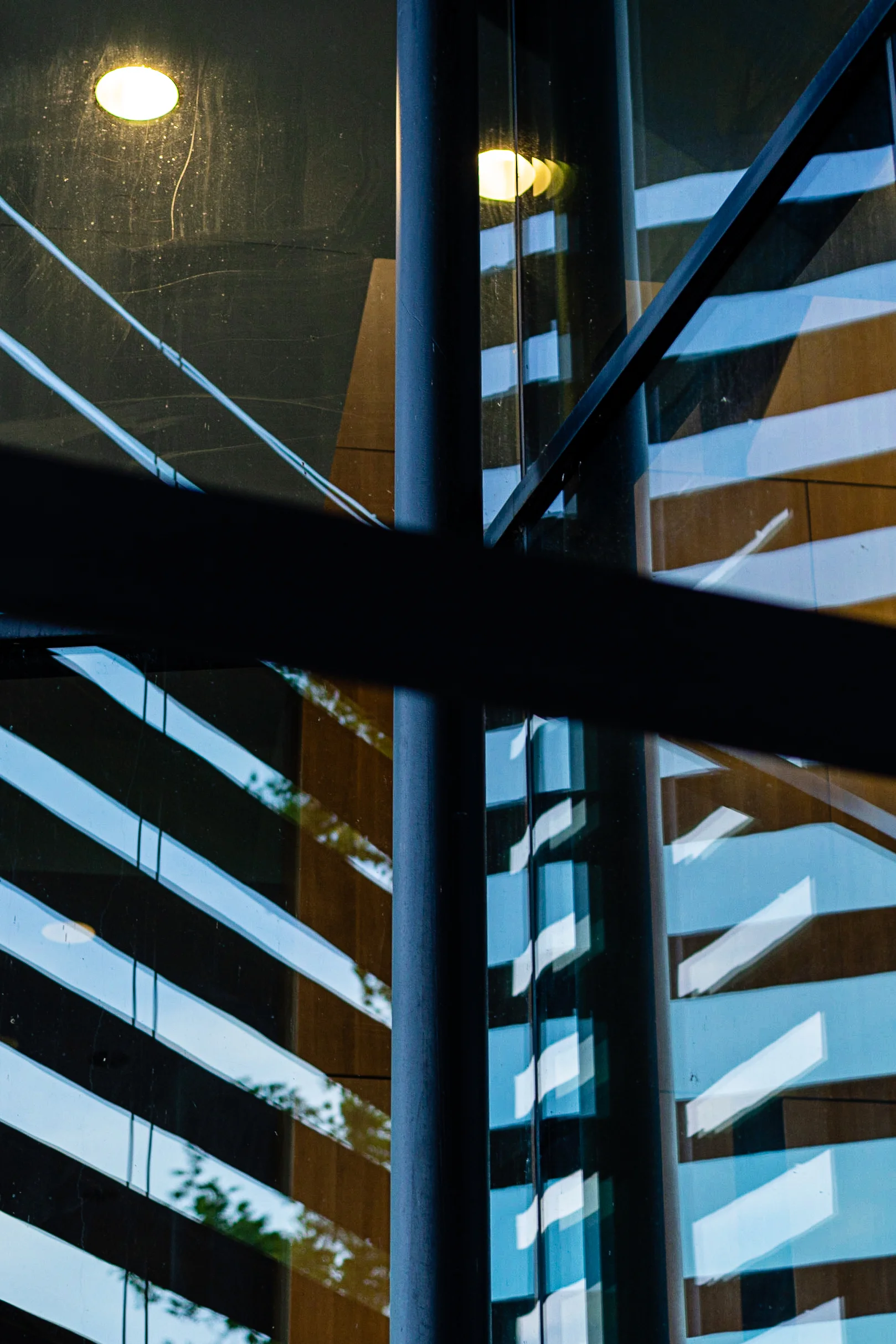 Brand & location — glass and steel building, layered reflections, blue tones