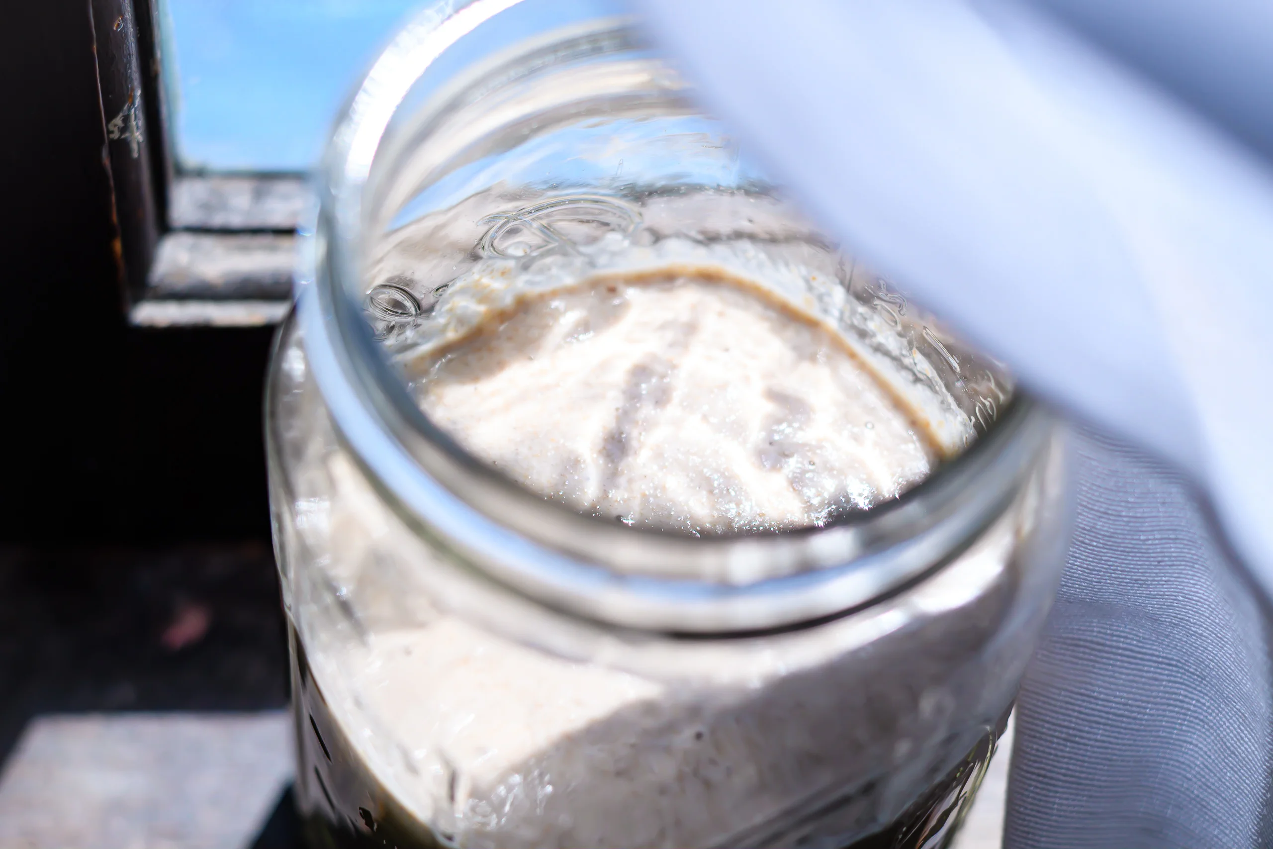 Brand & location — sourdough starter in mason jar, close detail, linen textile
