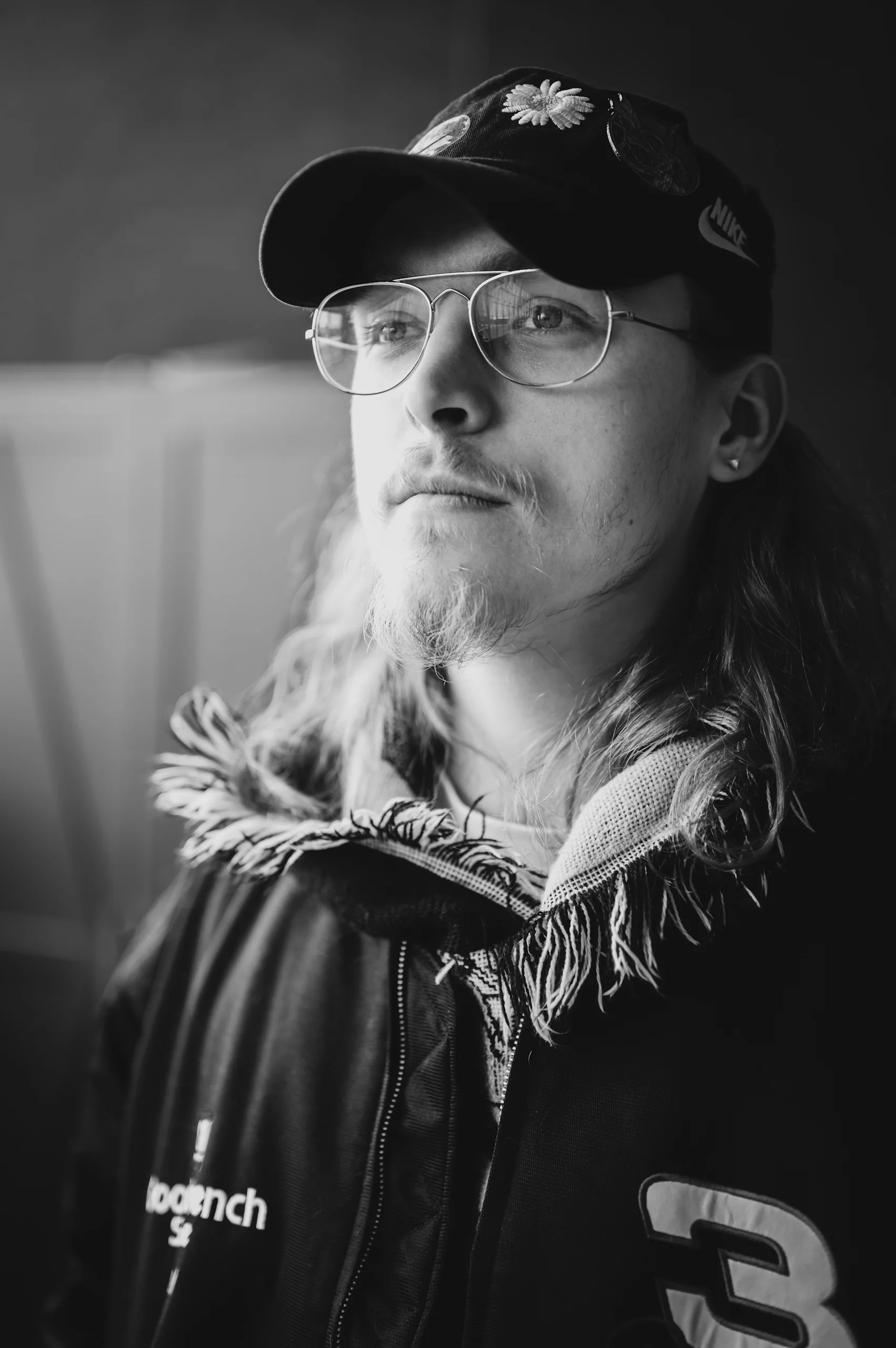 Portrait — man with long hair and daisy cap, looking away