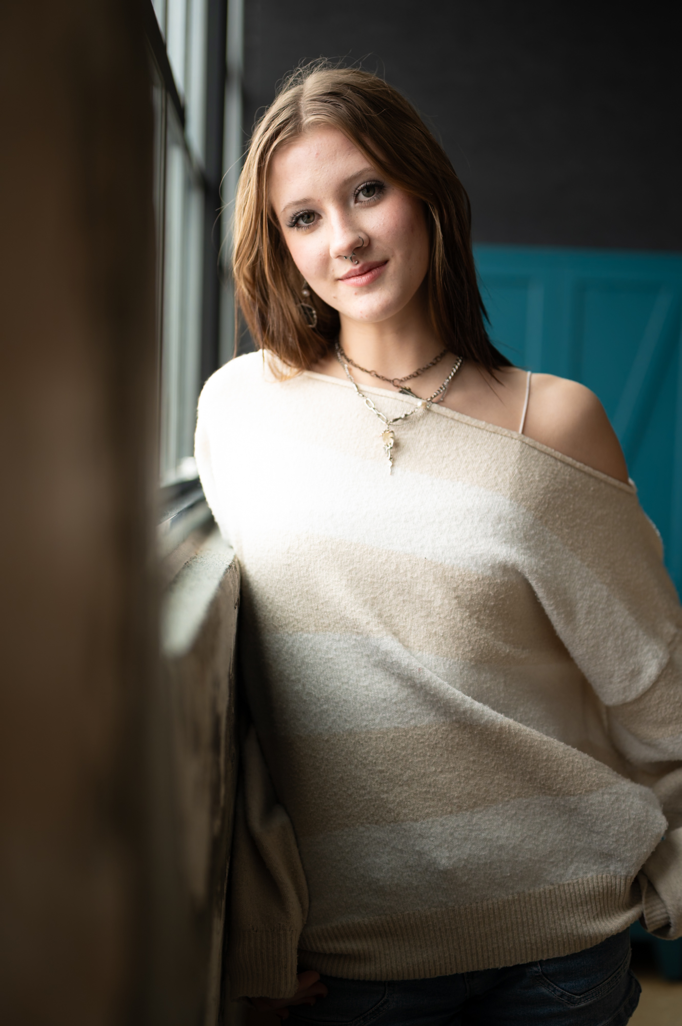 Portrait — woman leaning by window, smiling