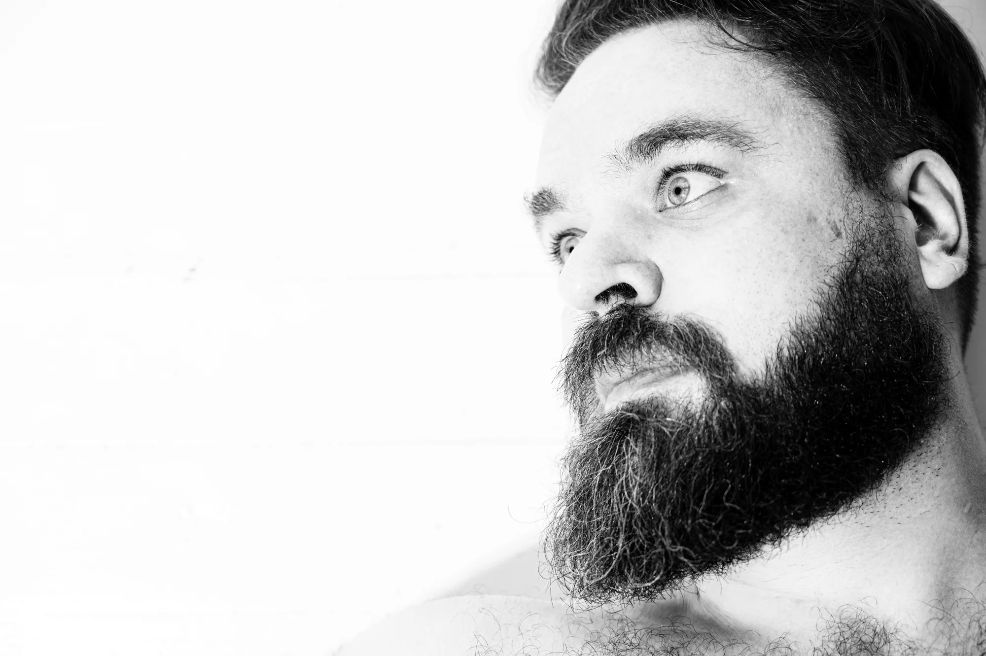 Portrait — man with beard, close monochrome, direct gaze
