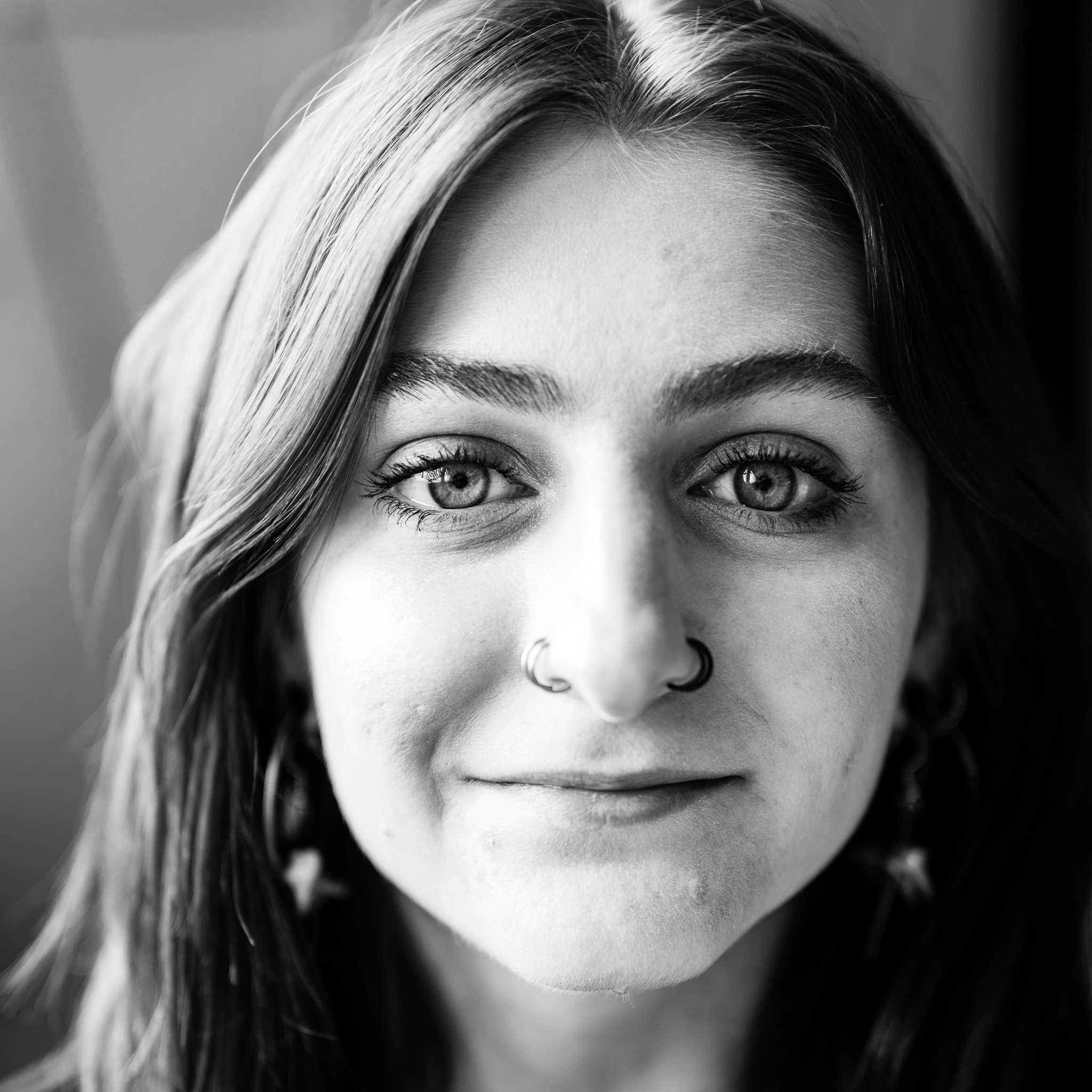 Portrait — woman with nose ring, direct gaze, natural light