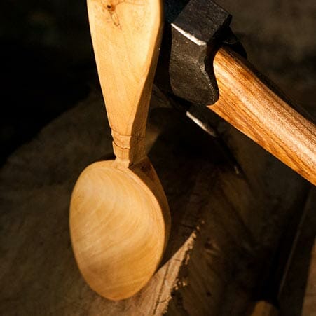 a wooden spoon resting against an axe